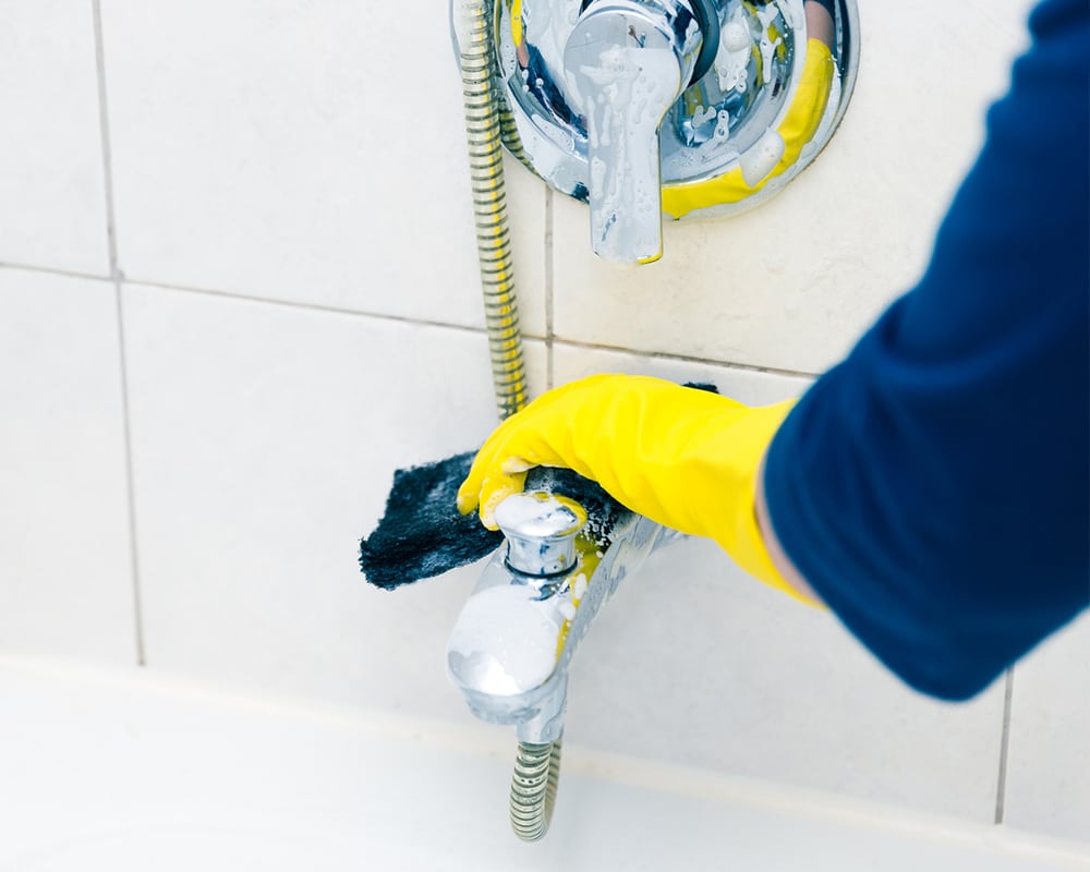 Technician performing kitchen and bathroom grout cleaning for tile maintenance